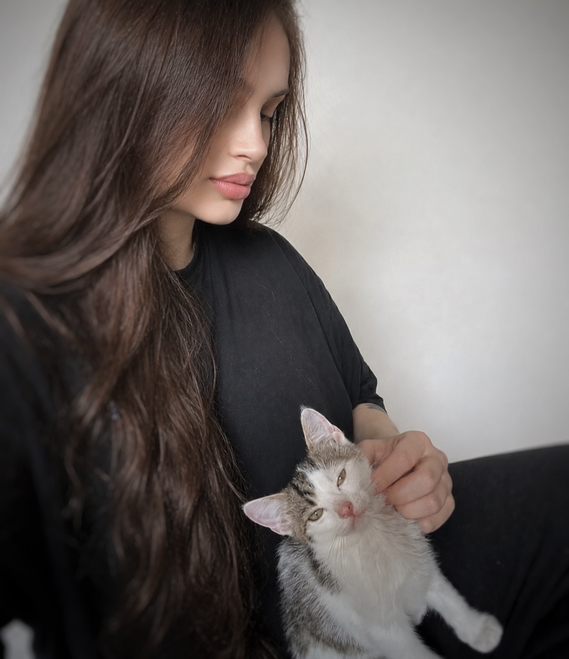 Mia gently holding a relaxed foster kitten